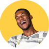 Image of young man smiling in front of yellow backdrop.